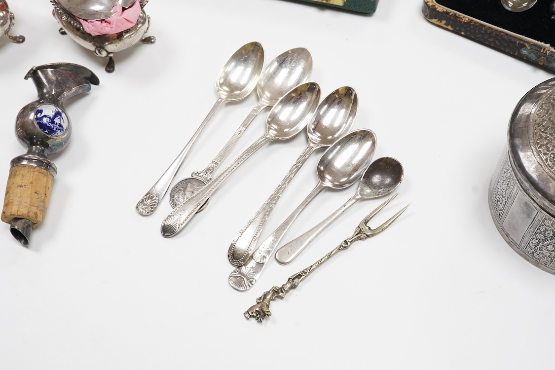 A collection of silver and white metal to include a 19th century Indian dressing table pot and cover chased with flowers, a three piece silver condiment set by Mappin and Webb with associated condiment spoon, three cased